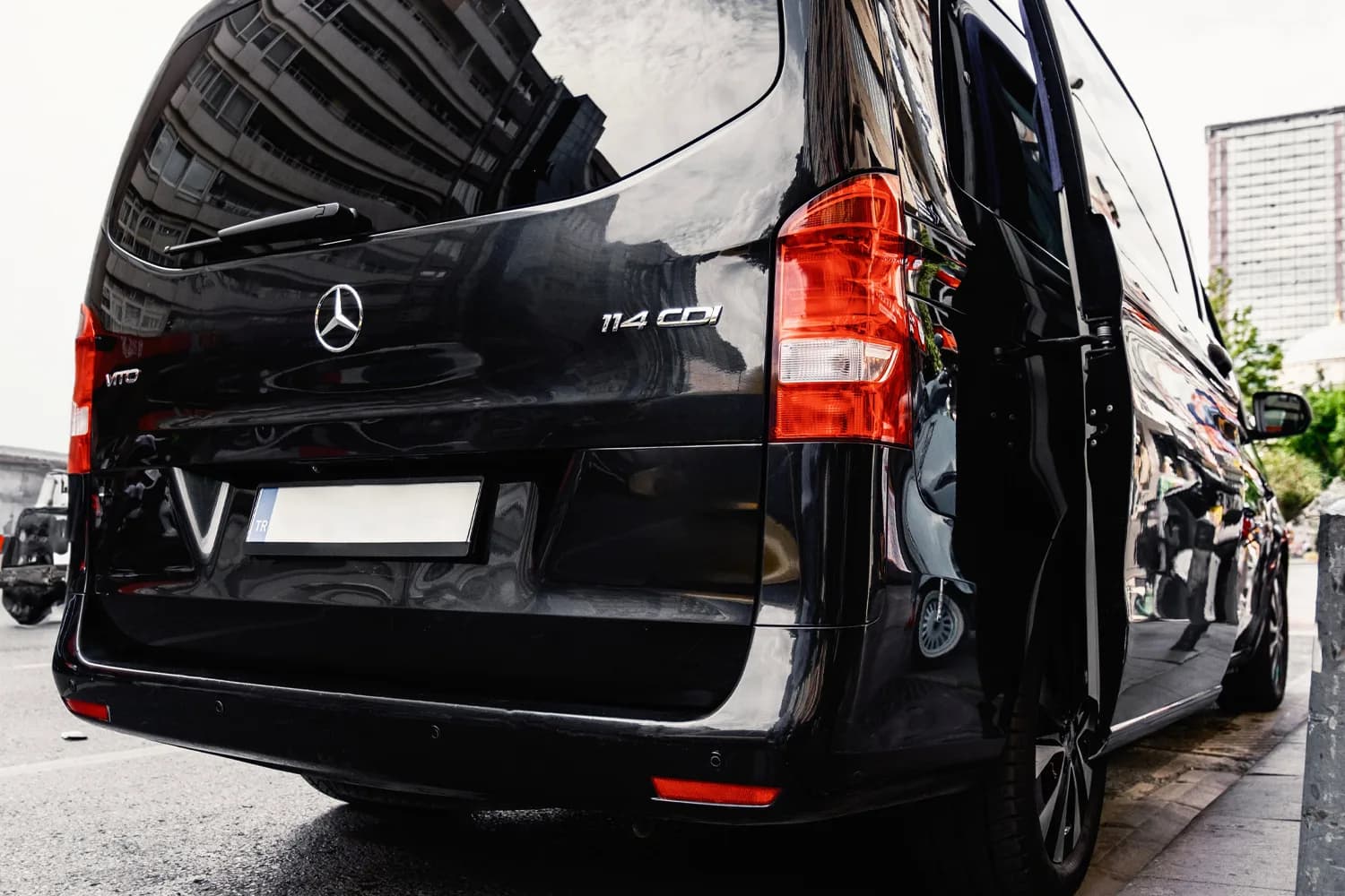 Schwarzer Mercedes Vito Shuttle-Bus mit geöffneter Schiebetür an einer Straße
